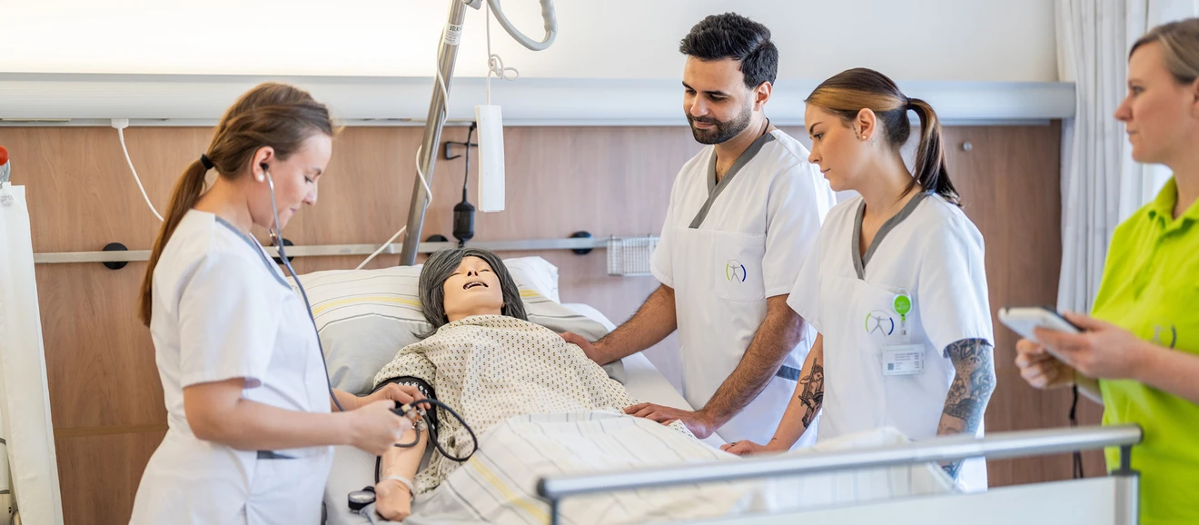 Pflegeschüler trainieren anhand einer Puppe am Krankenbett - die Pflegeschule der SALK